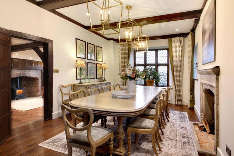 A dining room with a long table, leaded windows and a fireplace, in the Manor House, Lillibrooke Manor