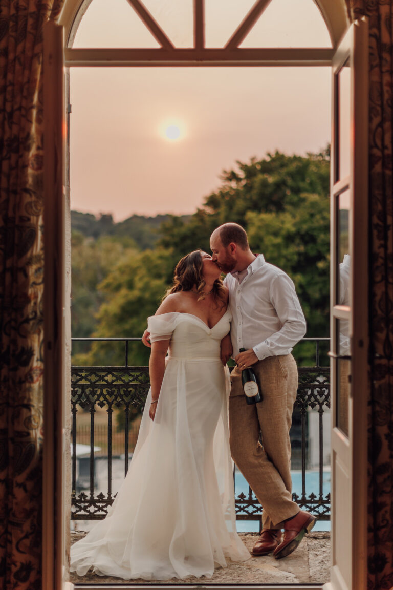 The couple at an open window at sunset, Chateau Naudou, Lina + Tom Photography