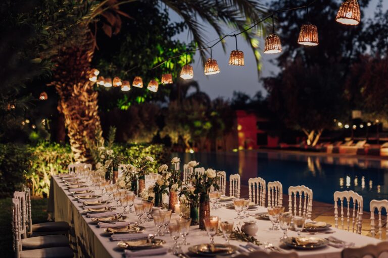 A long dinner table beside the pool under woven lanterns, Manzil La Tortue, Marrakech, Lina + Tom Photography