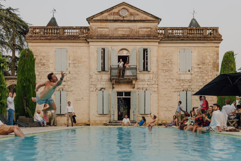 A guest dives into the pool in front of the chateau, Chateau Naudou, Lina + Tom Photography