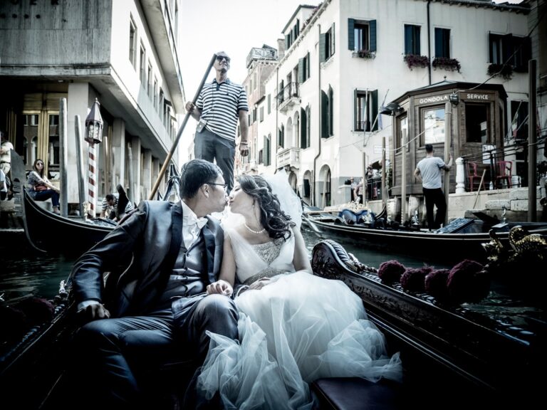 A bride and groom kissing in a gondola on a Venice canal, Lisa Semenzato
