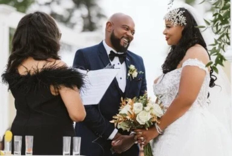 A couple with their officiant as a guest looks on, the groom holding the bride's bouquet, Living Ceremonies