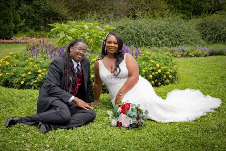 A couple relaxing on the grass among flower beds, Living Ceremonies