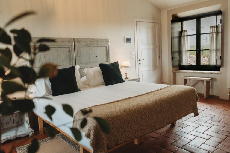 A bedroom with a double bed, a tiled floor and dark-framed windows, Locanda in Tuscany