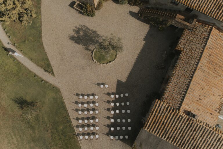 Ceremony chairs set out beside the terracotta-tiled roof, seen from above, Locanda in Tuscany