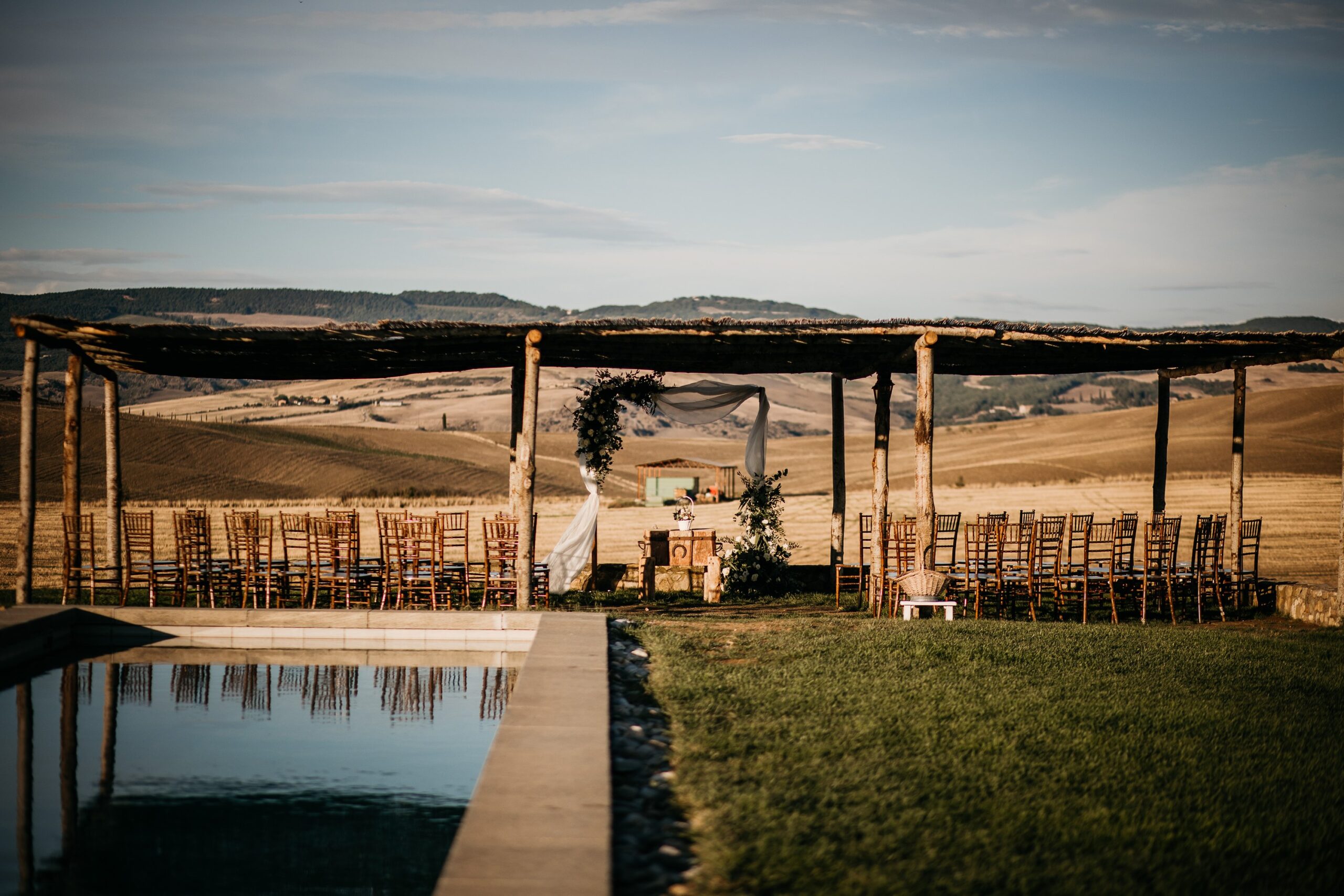 The swimming pool and the reed-roofed pergola with hills behind