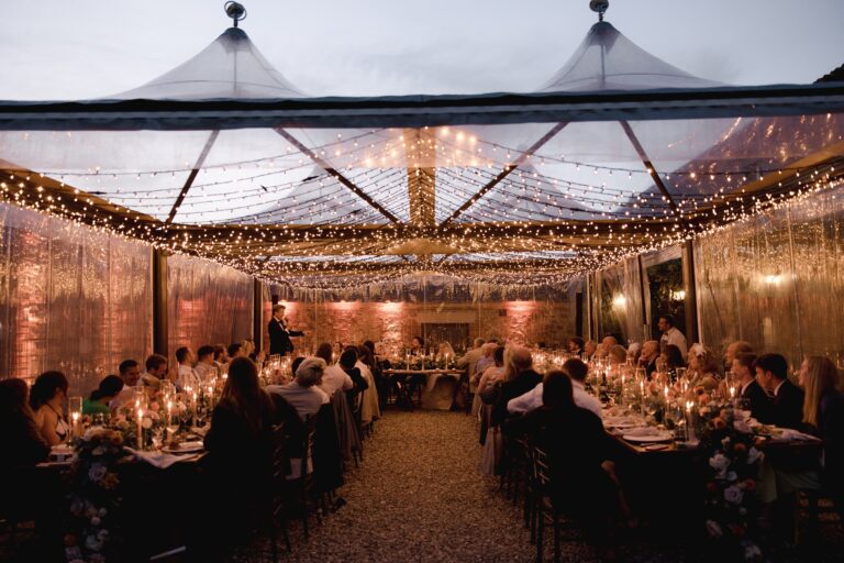 A glass-roofed marquee lit with fairy lights for an evening dinner, Locanda in Tuscany