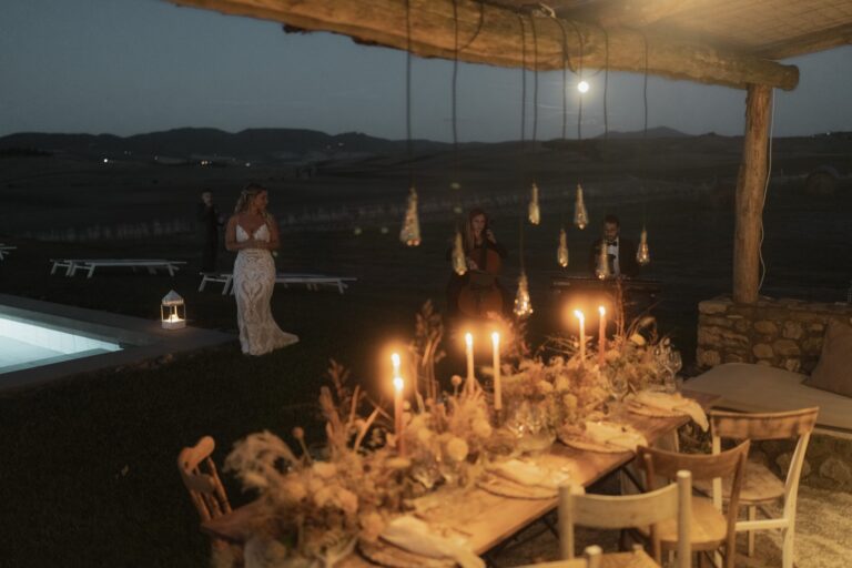 A candlelit table beside the pool at night, Locanda in Tuscany