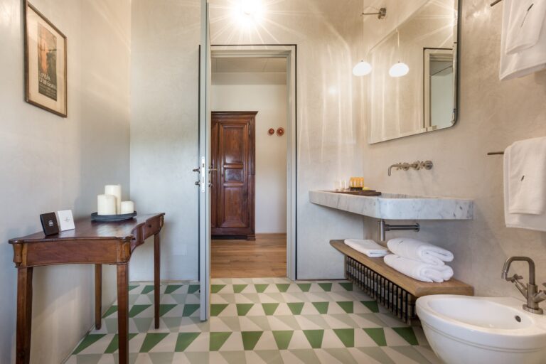 A bathroom with a marble basin and a geometric tiled floor, Locanda La Raia
