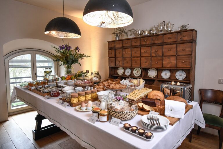 A breakfast table laid with pastries, preserves and tableware, Locanda La Raia