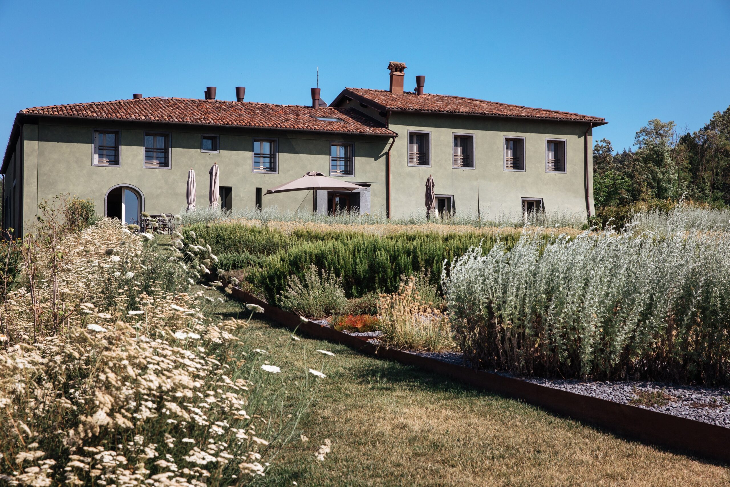 The house with its terracotta roof, seen across the herb and meadow gardens, Locanda La Raia