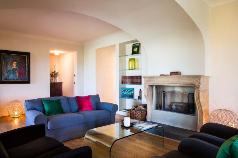 A sitting room with a fireplace and a blue sofa, Locanda La Raia