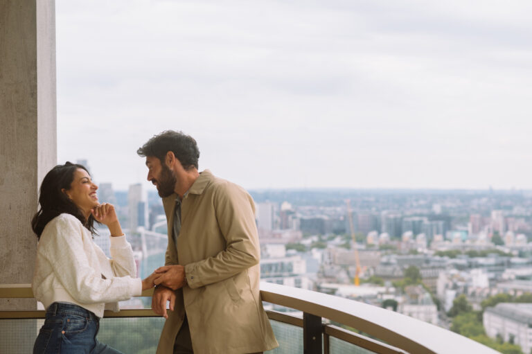 A couple on a high-level balcony above the city, London Hilton on Park Lane
