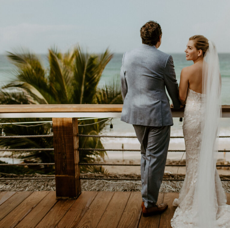 A couple on the timber deck above the beach, Long Bay Beach Resort