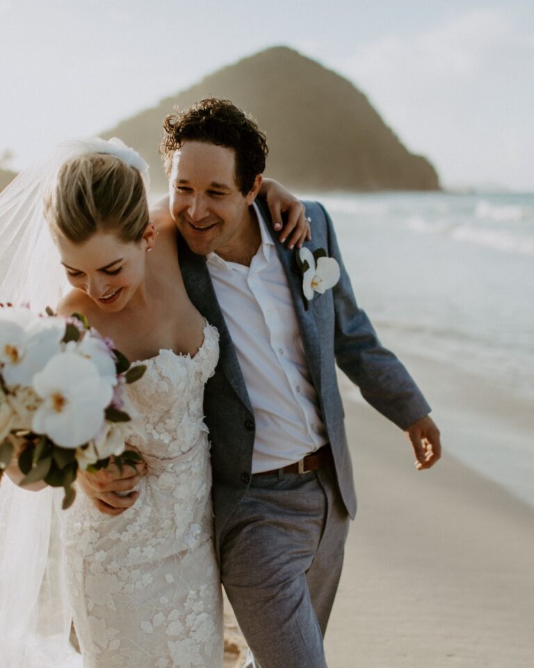A couple with a bouquet on the beach, Long Bay Beach Resort