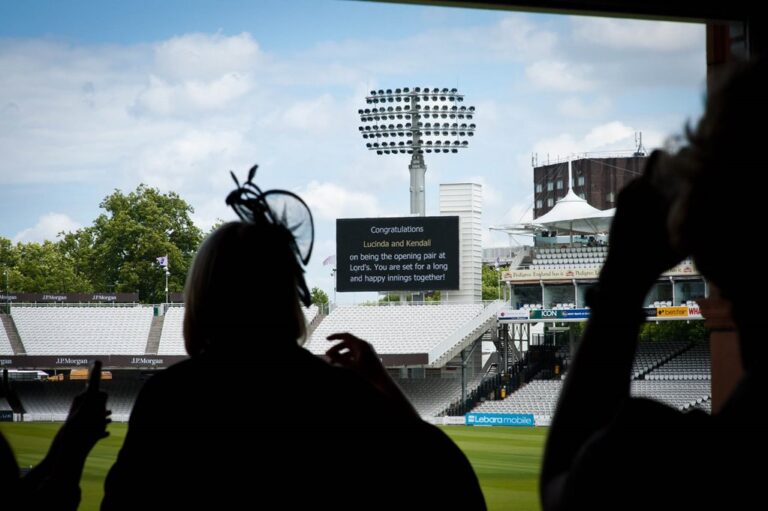 A guest at the window as the scoreboard carries a message for the couple, Lord’s Cricket Ground