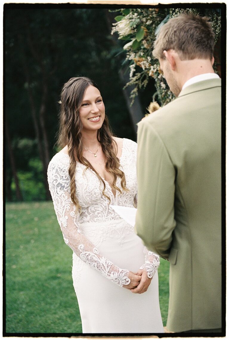 A bride in a lace long-sleeve gown, close with her groom, Lorella Giannini