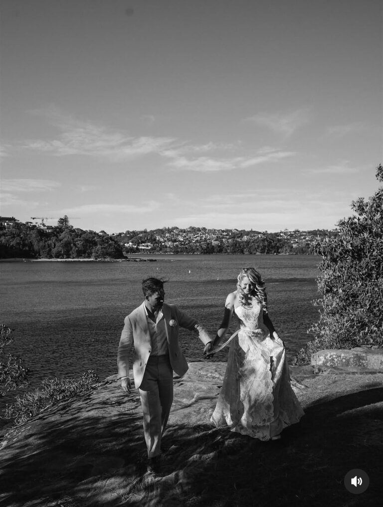 A couple walk beside the water at sunset, Lorella Giannini