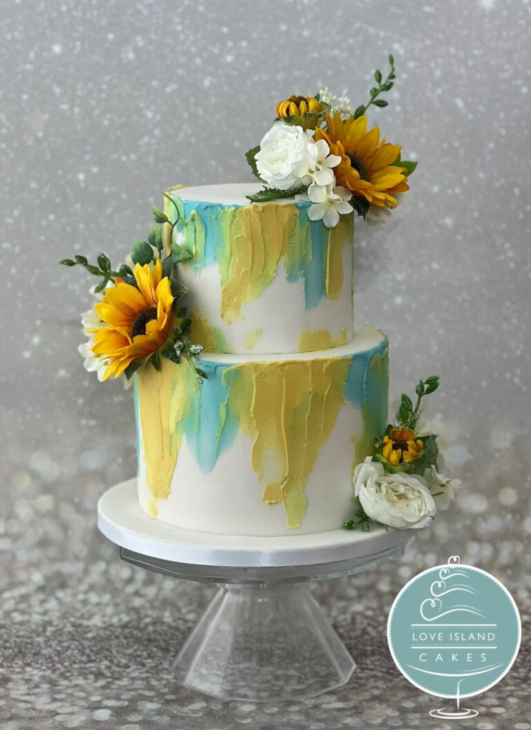 A two-tier cake with yellow and teal watercolour brushwork and sunflowers, Love Island Cakes