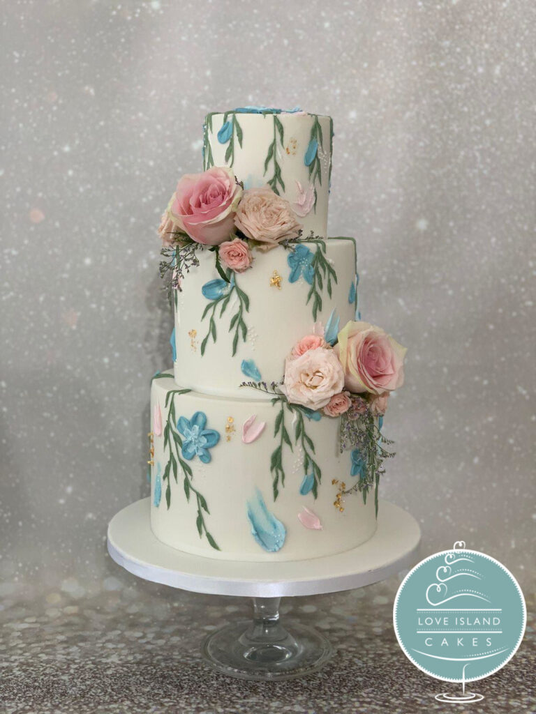A three-tier cake hand-painted in soft watercolour willow leaves with pink roses, Love Island Cakes