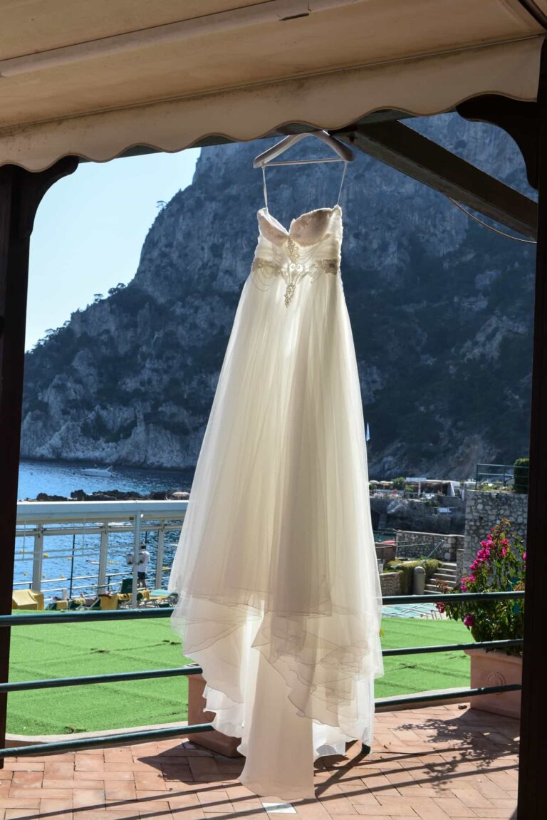 The wedding dress hanging in a window above the sea on Capri, Lovexposed Photography
