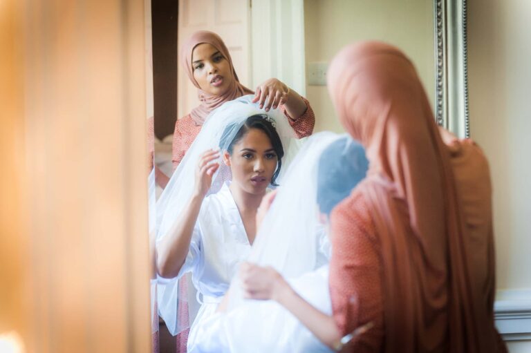 The veil goes on during the morning preparations; Joelle and Tashan's wedding at Gilwell, Essex, Lovexposed Photography
