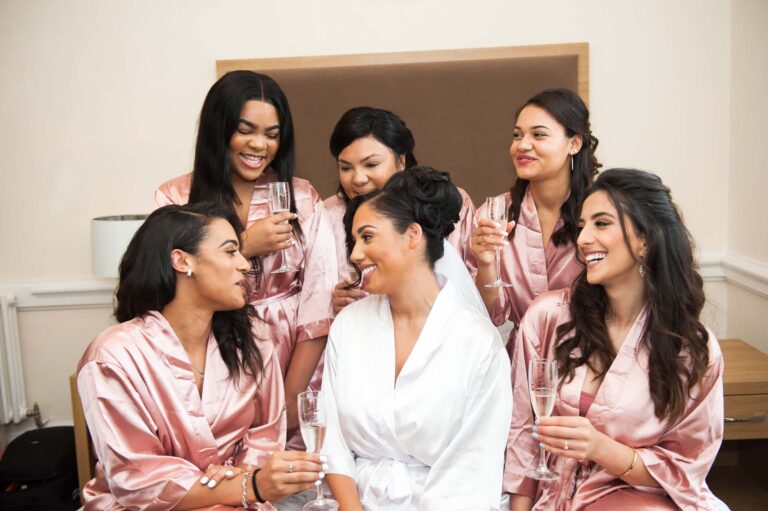 The bride and her bridesmaids in matching robes during preparations; Joelle and Tashan's wedding at Gilwell, Essex, Lovexposed Photography