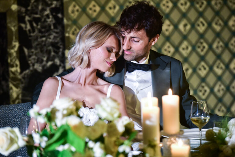The couple at a candlelit table dressed with white roses on the Paestum styled wedding shoot in the Cilento, Lovexposed Photography
