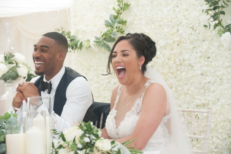 The couple laughing during the speeches; Joelle and Tashan's wedding at Gilwell, Essex, Lovexposed Photography