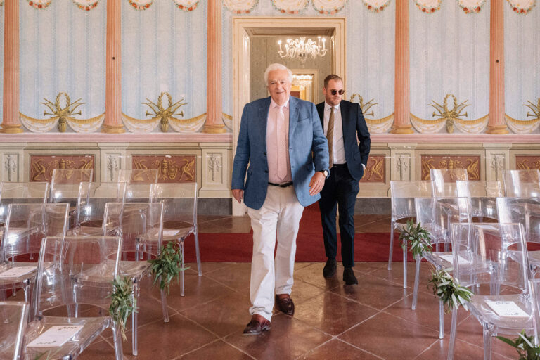 A painted ceremony hall in Noto set with clear chairs and white flowers, LOVIÙ Events
