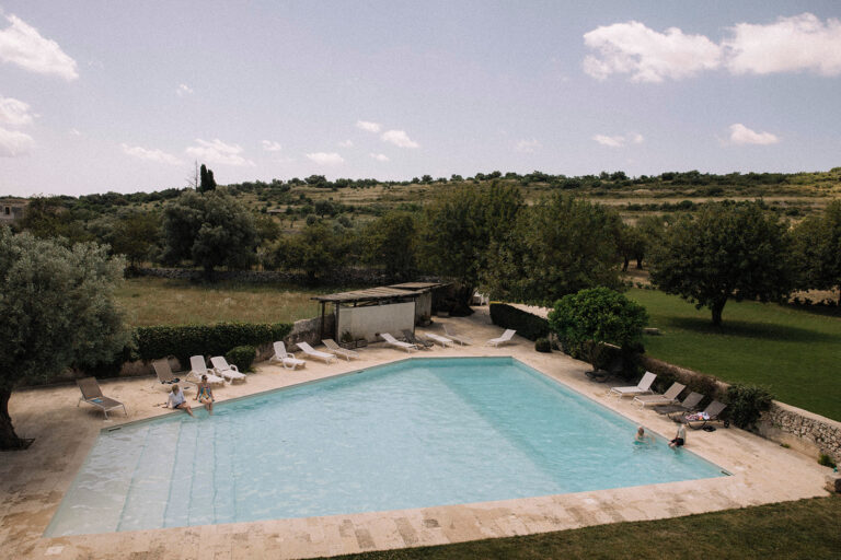 The pool and olive-dotted countryside at the venue for Emily and Richard's wedding near Noto, LOVIÙ Events