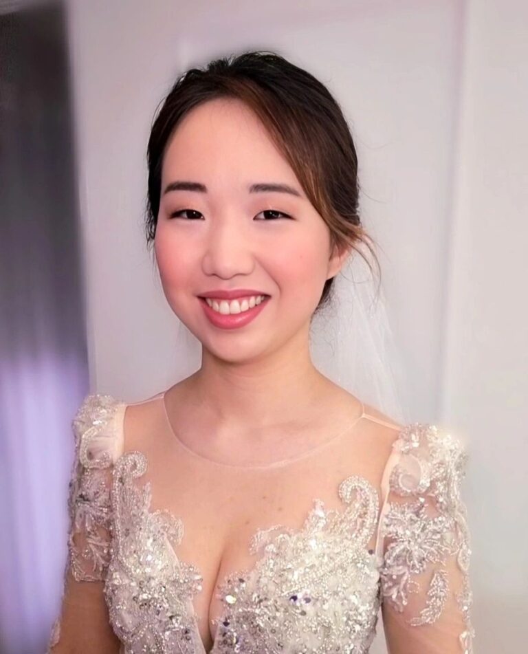 A bride in a sparkling lace gown, veil catching the light, mid-laugh, Loxus Hair and Makeup
