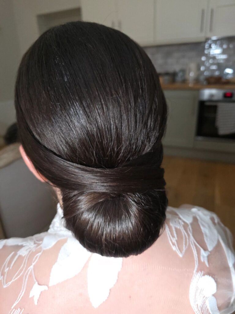 A sleek, low bun, styled in a kitchen doorway, Loxus Hair and Makeup