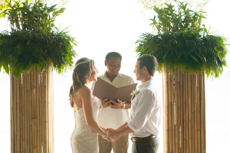 A celebrant marrying a couple between two bamboo columns planted with ferns and white flowers, Rayavadee, Krabi, Lucida Image