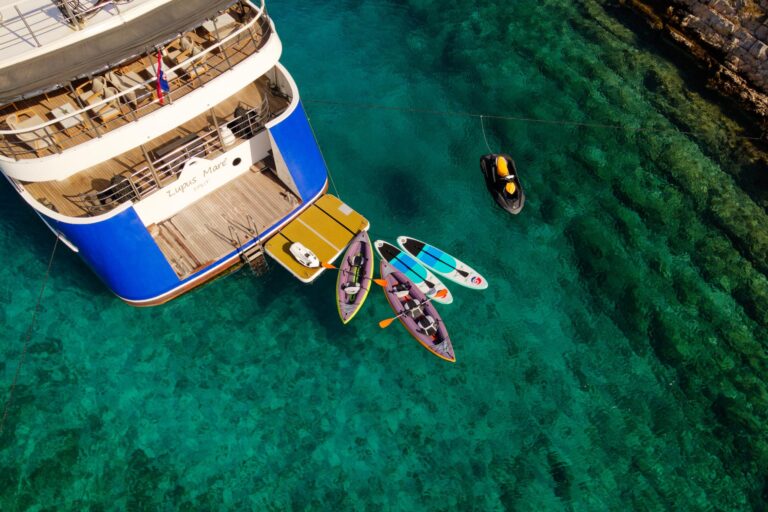 Stern platform, kayaks, paddle boards and jet ski in clear water, Lupus Mare