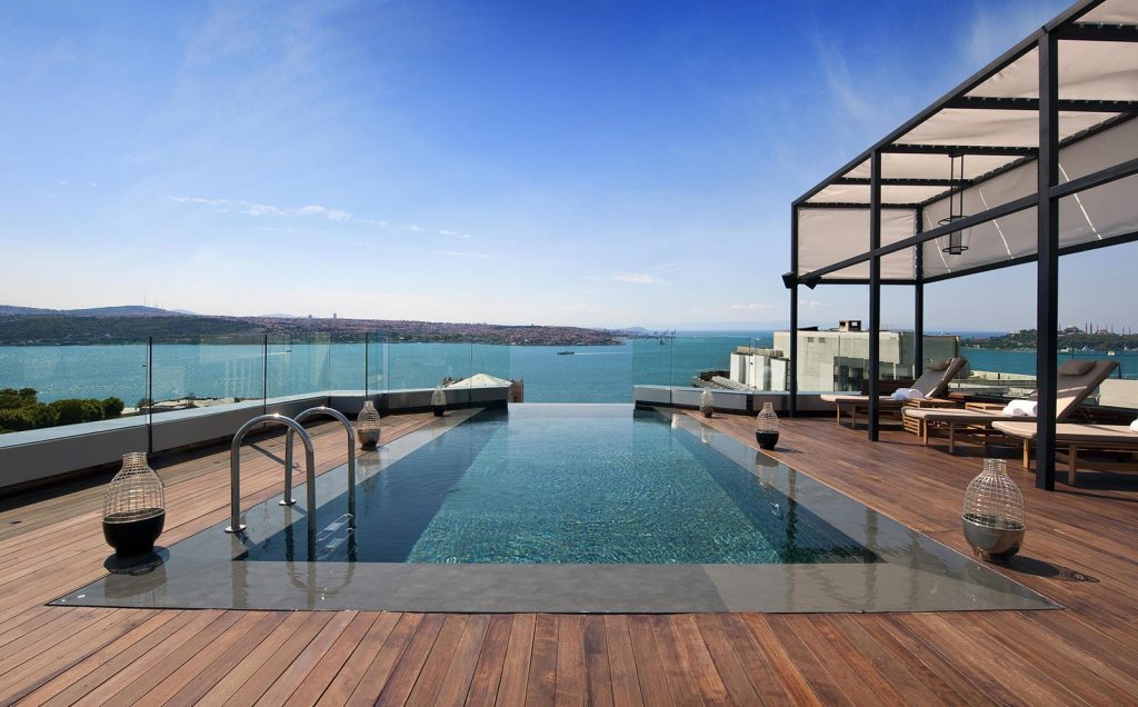 A rooftop infinity pool and timber deck looking out over the Bosphorus