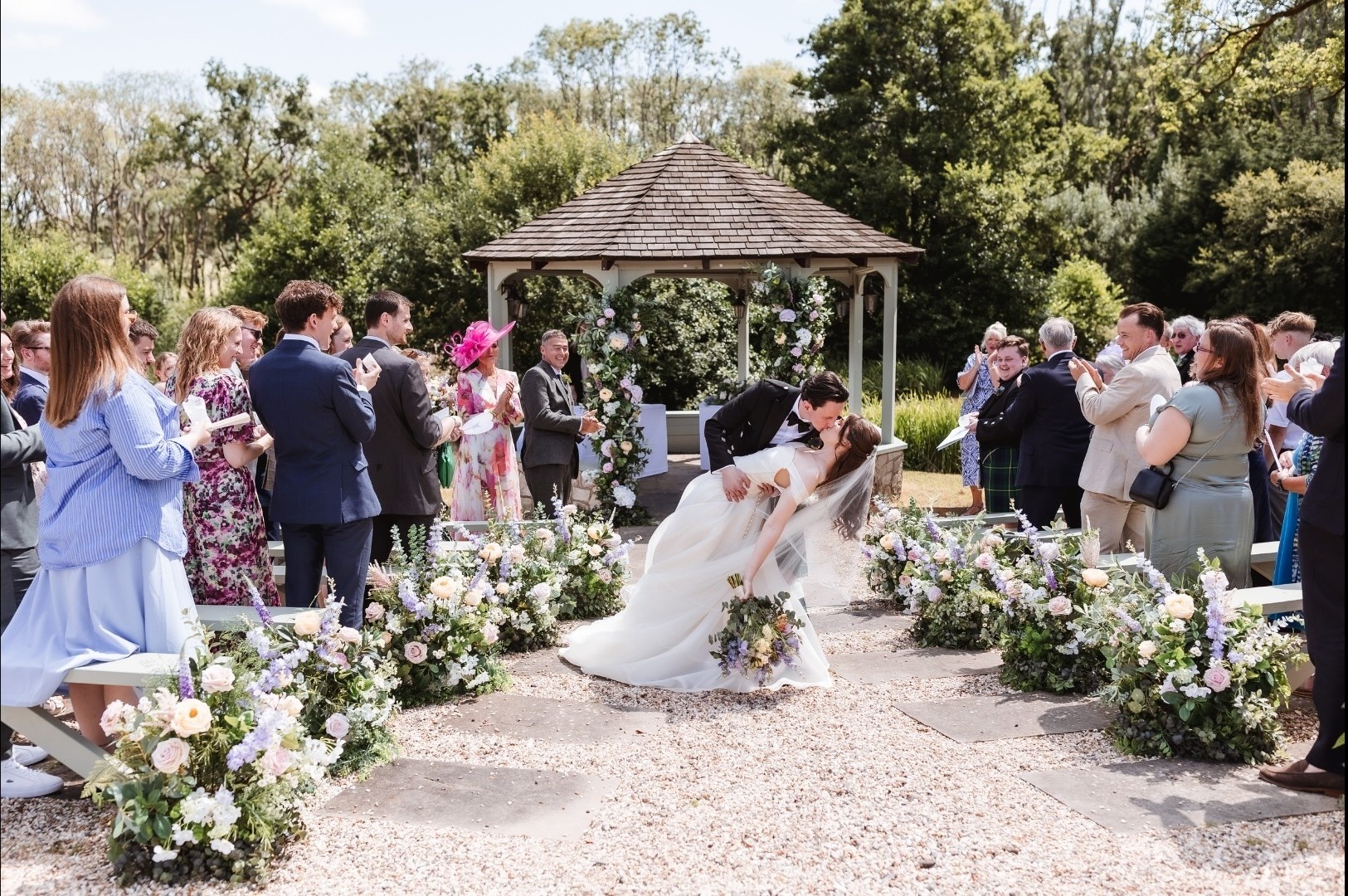 A bride at the lakeside gazebo, dressed with flowers, for an outdoor civil ceremony, Lythe Hill Hotel & Spa