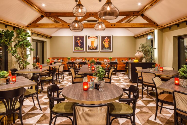 A beamed dining room set with round tables and candles for a wedding dinner, Lythe Hill Hotel & Spa