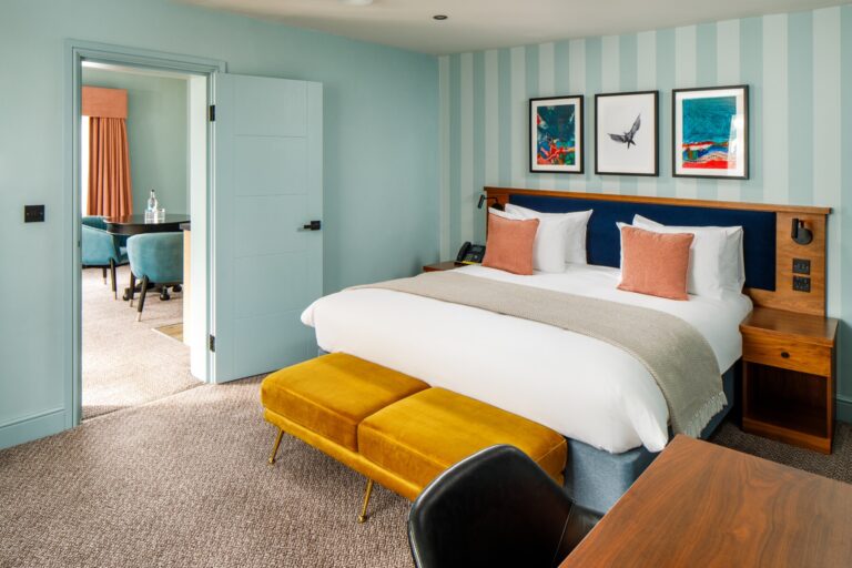 A bright bedroom with an upholstered bed and pops of yellow and blue, Lythe Hill Hotel & Spa