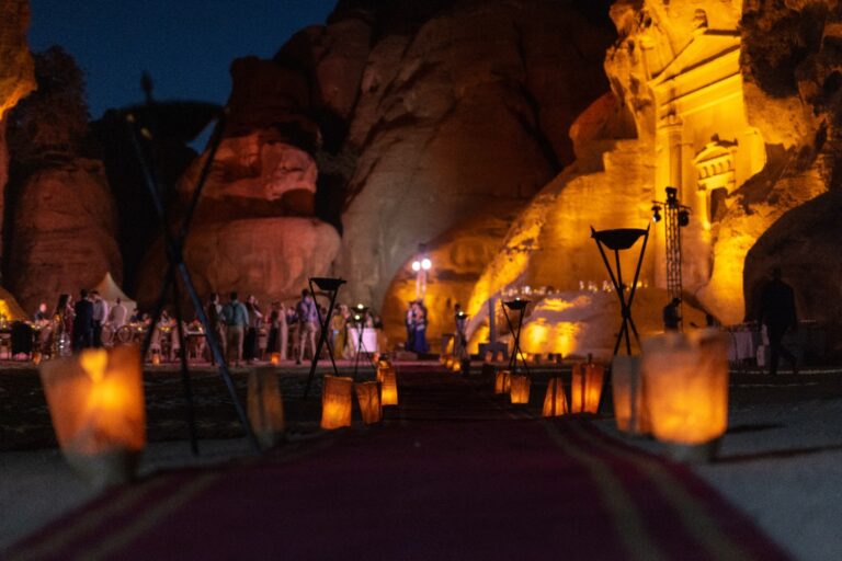 Lantern-lit walkway toward the lit facade at night, Mövenpick Resort Petra