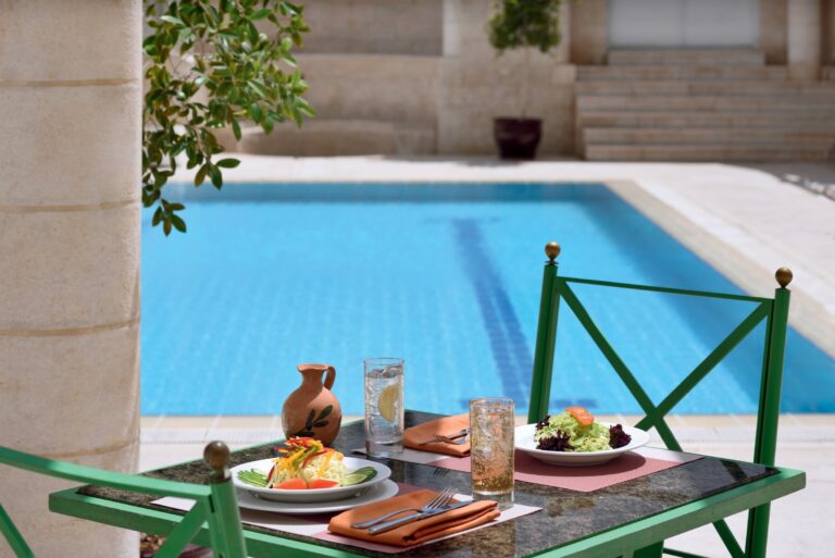 Outdoor swimming pool with poolside table, Mövenpick Resort Petra