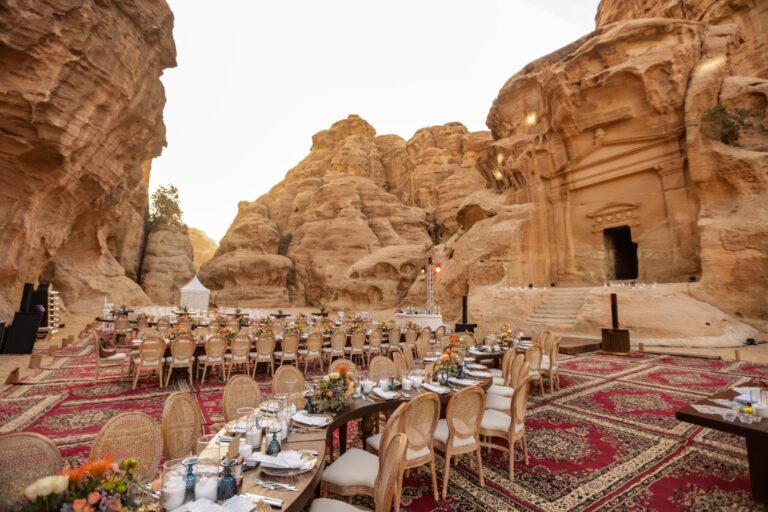 Wedding dinner tables laid on carpets in the Little Petra rock setting, Mövenpick Resort Petra