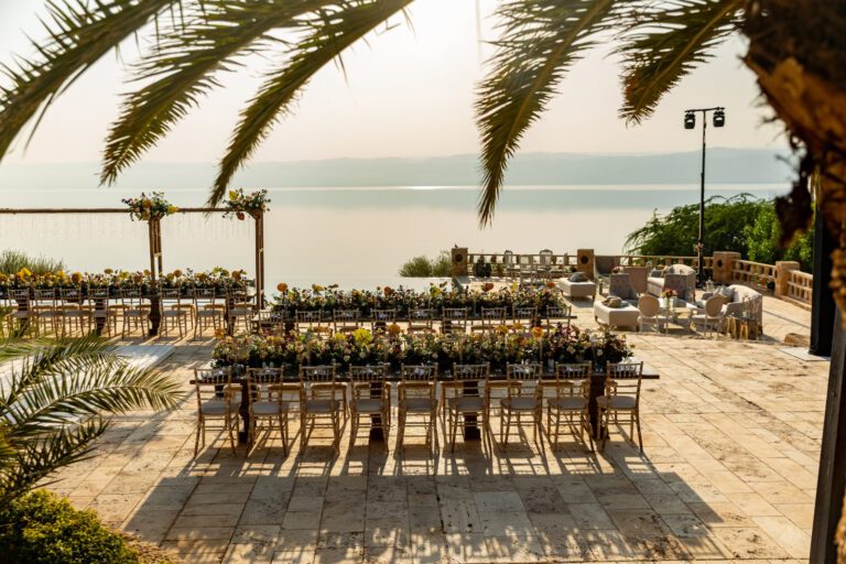 Long reception table on the terrace beneath palms, Mövenpick Resort & Spa Dead Sea