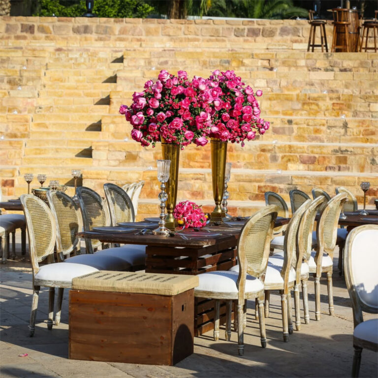 Dining tables with floral centrepieces against the stone tiers, Mövenpick Resort & Spa Dead Sea