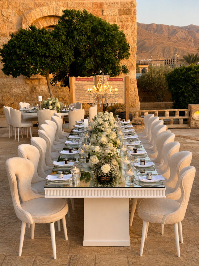 Long table by the Zara Spa infinity pool, with a stone archway beyond, Mövenpick Resort & Spa Dead Sea