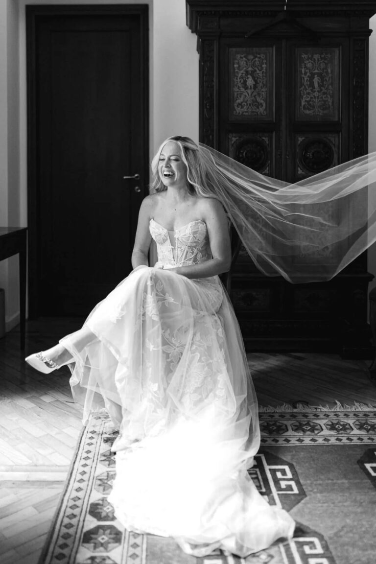The bride on the stairs in black and white, her veil thrown out behind her, Magnolia Wedding Planner