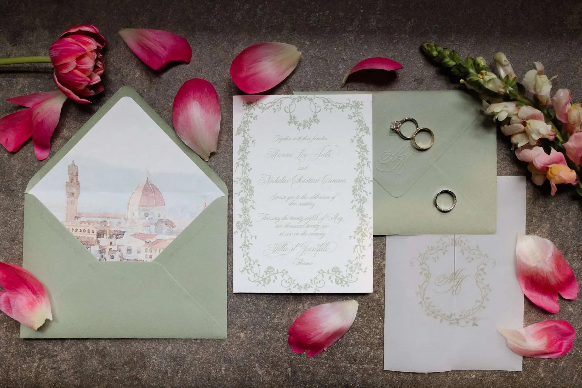 The invitation, the rings and magnolia petals laid on green paper, Magnolia Wedding Planner