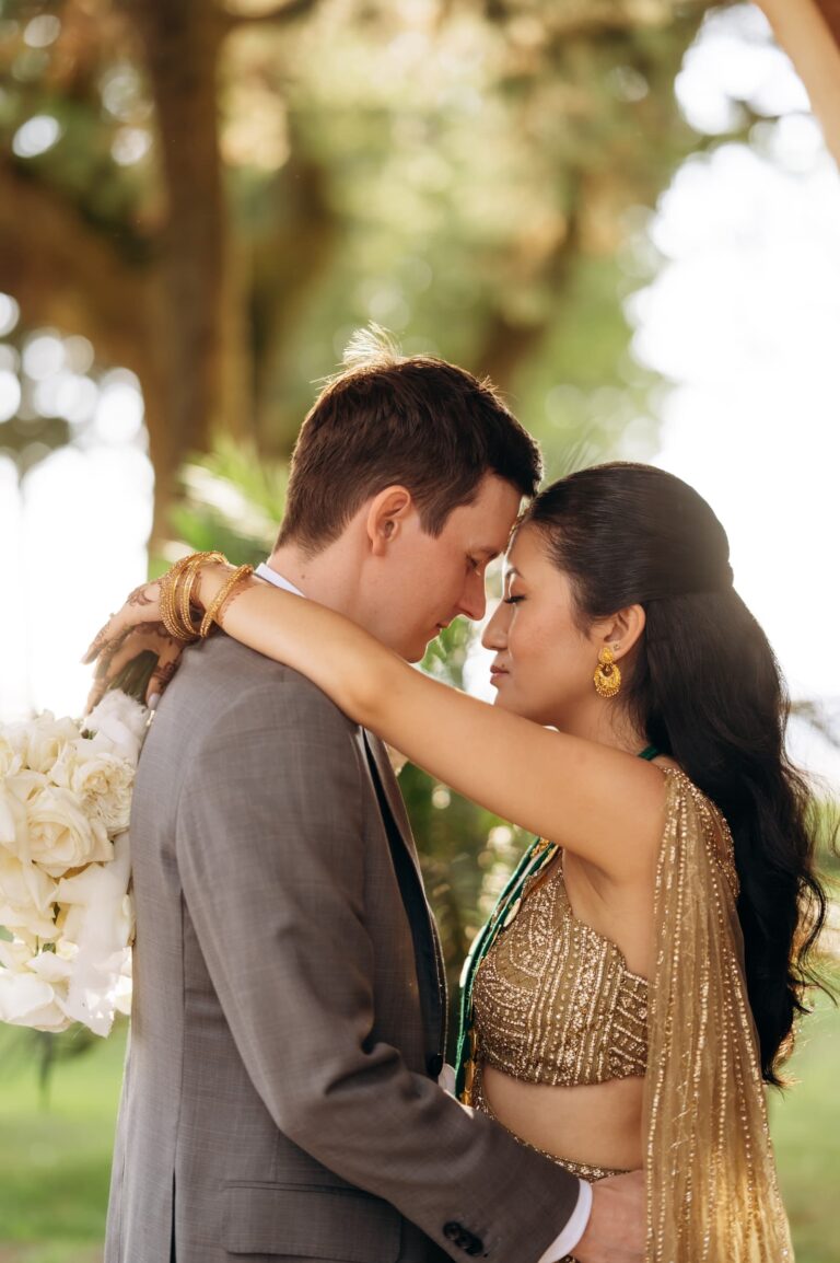 The couple close together in the garden, the gold catching the light, Magnolia Wedding Planner
