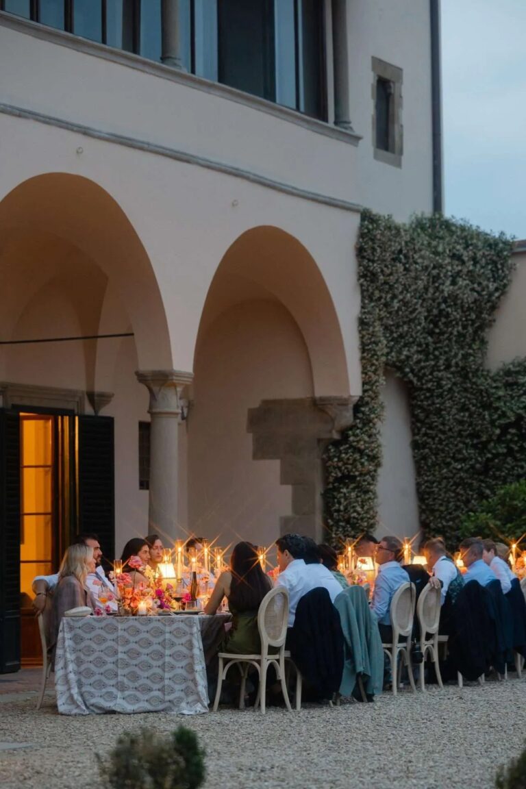 Dinner in the loggia after dark, guests lit by candles alone, Magnolia Wedding Planner