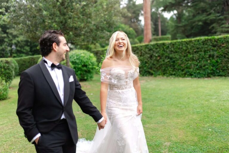 The couple laughing on the lawn, cypresses and a stone pine behind them, Magnolia Wedding Planner